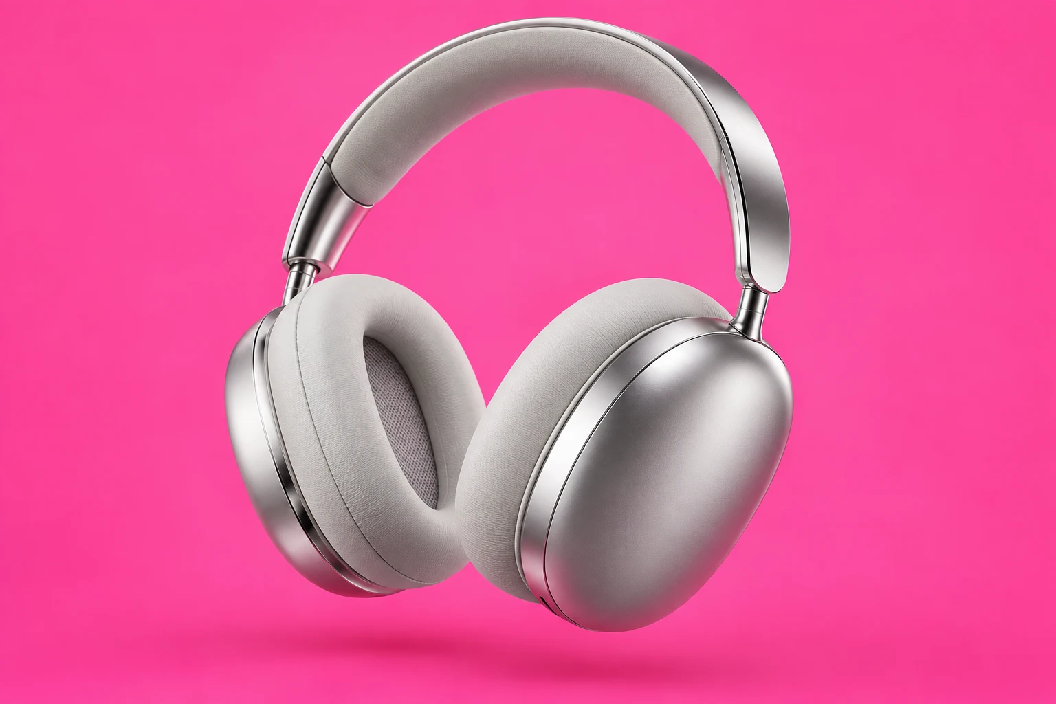 Silver over-ear headphones against a vivid pink backdrop